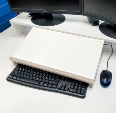 Schreibtischhelfer Ein Schreibtisch mit zwei Monitoren, Tastatur und Maus auf einer weißen Fläche.